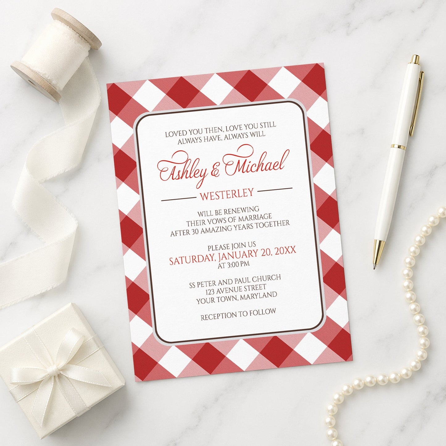Red Gingham Vow Renewal Invitation shown on a marble surface with a white gift box, pen, ribbon, and pearls.