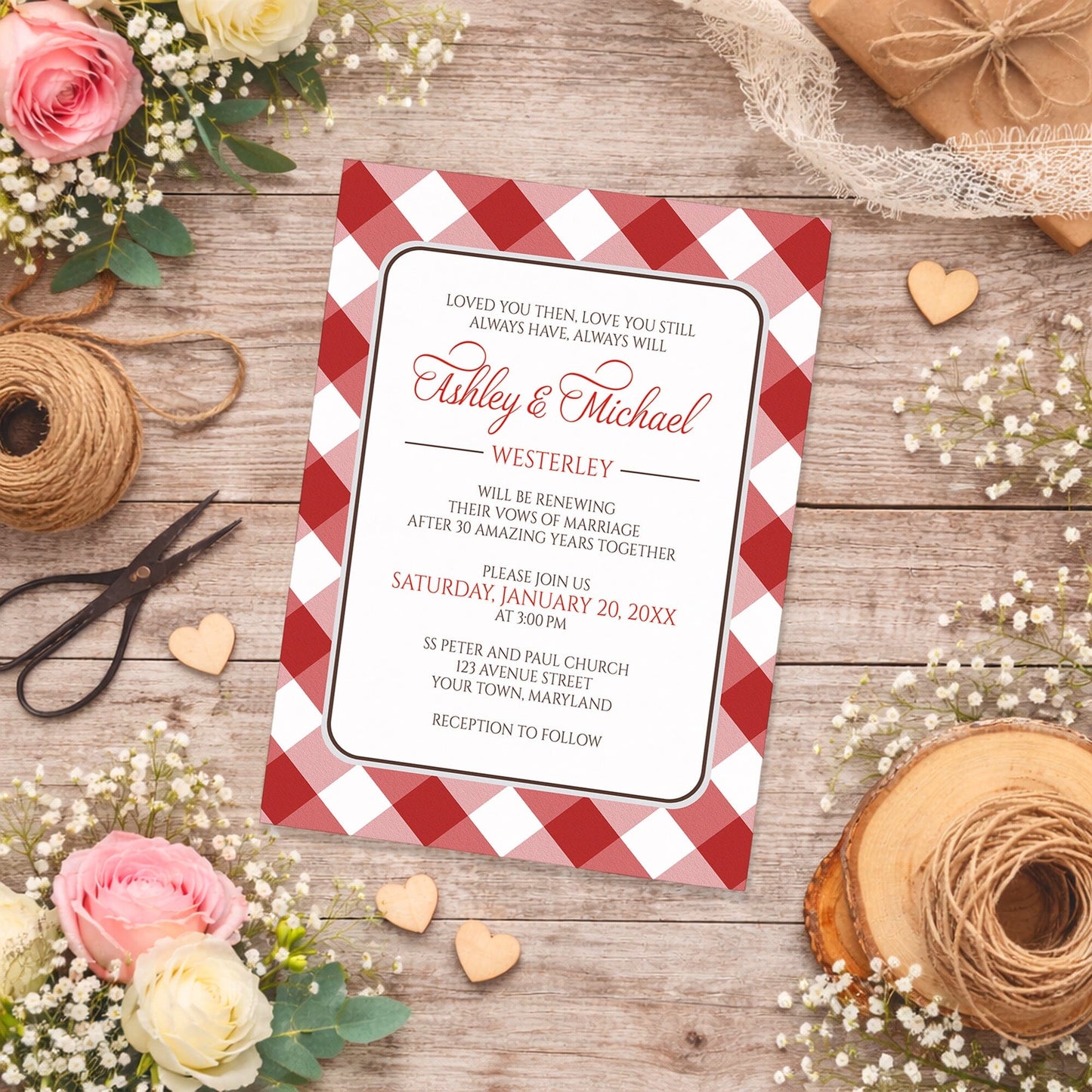 Red Gingham Vow Renewal Invitation shown on a wooden surface with spring and summer flowers, small wood hearts, and twine.