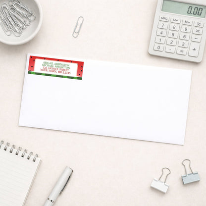 Red and Green Watermelon Address Label shown on a white envelope with everyday office supplies