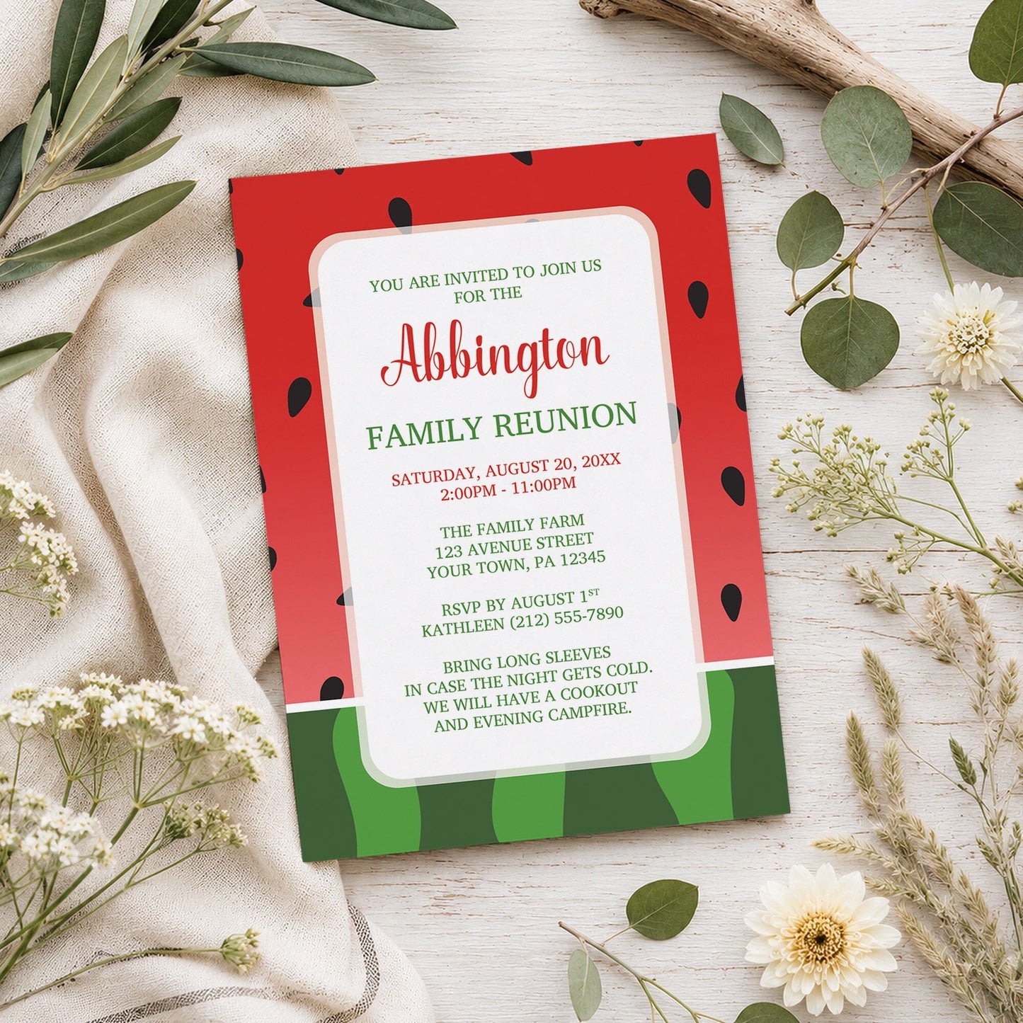 Red and Green Watermelon Family Reunion Invitation shown on a wooden surface with spring and summer plants.