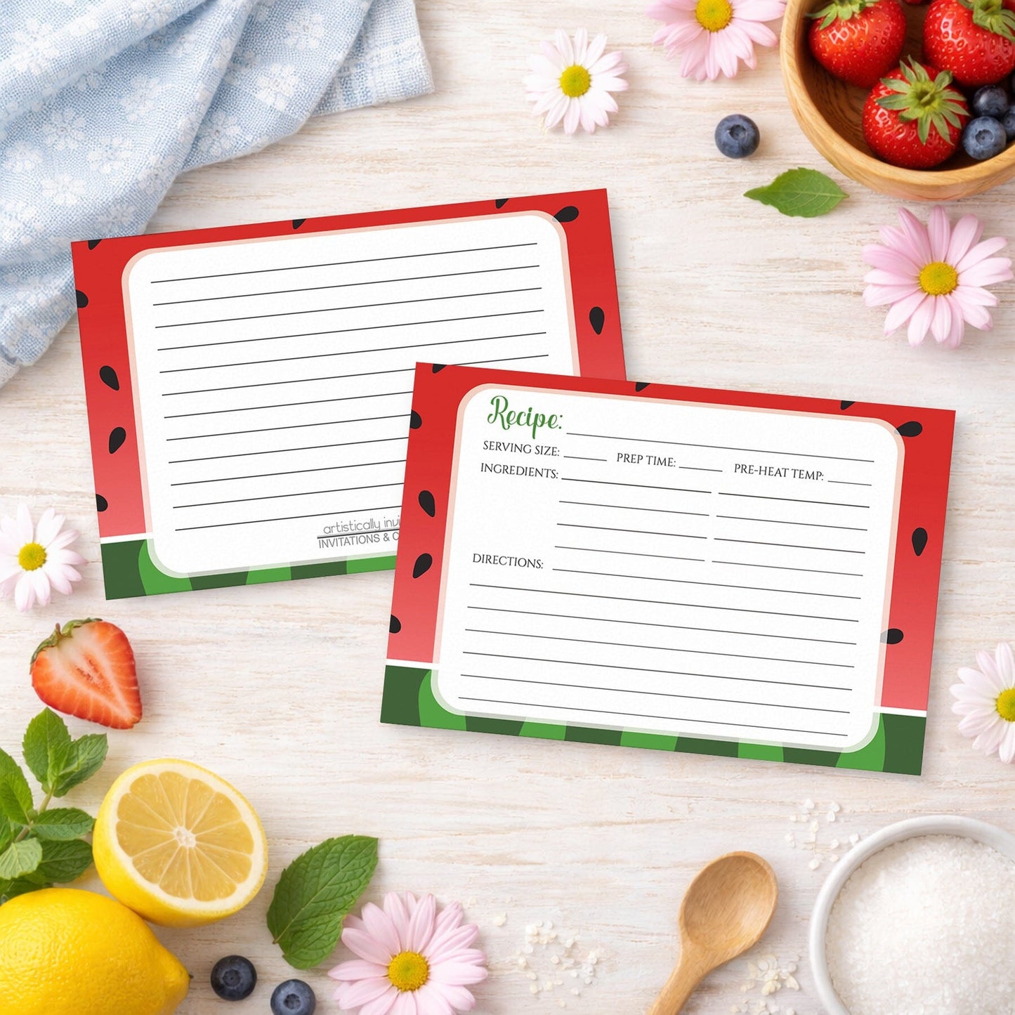 Two Red and Green Watermelon Recipe Cards on a wooden surface with spring and summer fruits and flowers.
