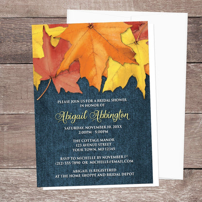 Rustic Autumn Leaves Denim Bridal Shower Invitation shown on a wooden surface with a white envelope.
