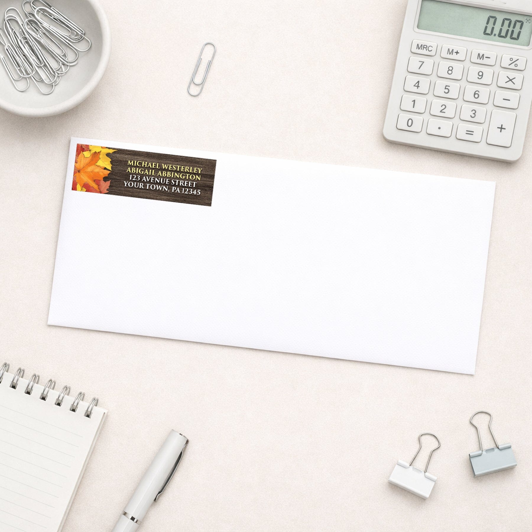 Rustic Autumn Leaves Wood Address Label shown on a white envelope with office supplies