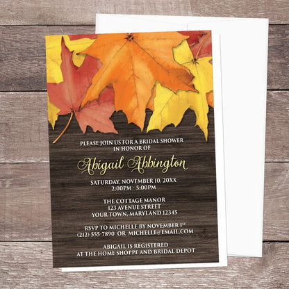 Autumn-themed bridal shower invitation with leaves on a wooden background, laid on a wooden tabletop with a white envelope