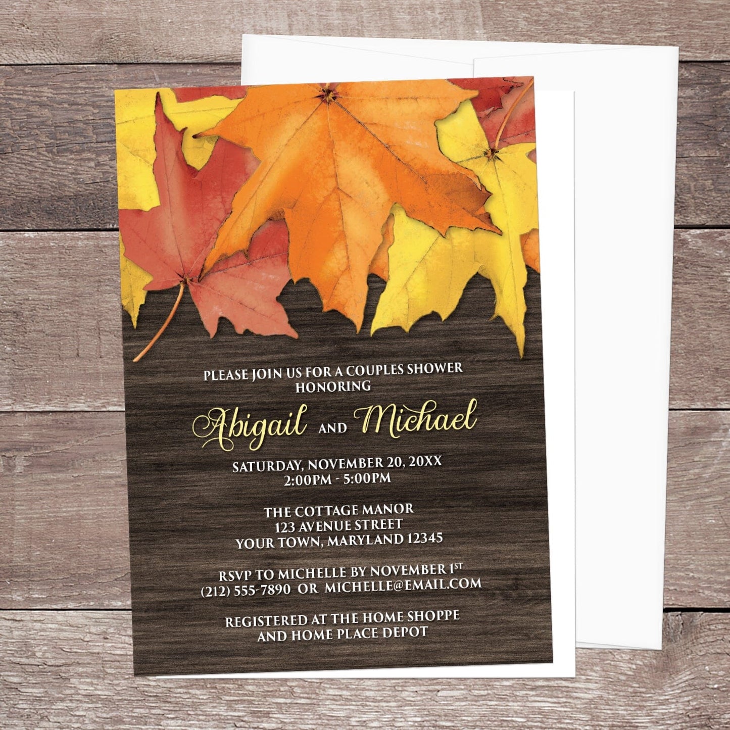 Rustic Autumn Leaves Wood Couples Shower Invitation shown on a brown wood surface with a white envelope.
