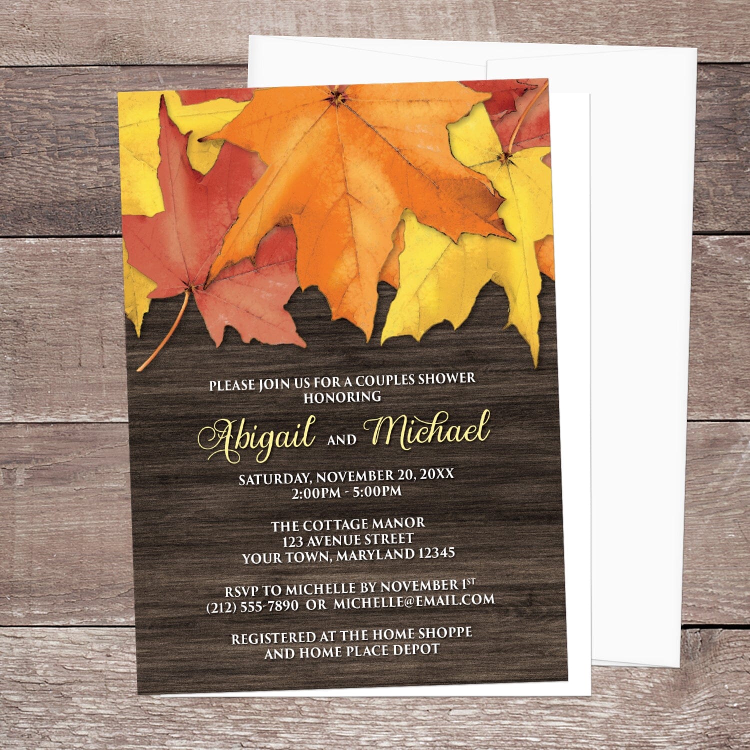 Rustic Autumn Leaves Wood Couples Shower Invitation shown on a brown wood surface with a white envelope.