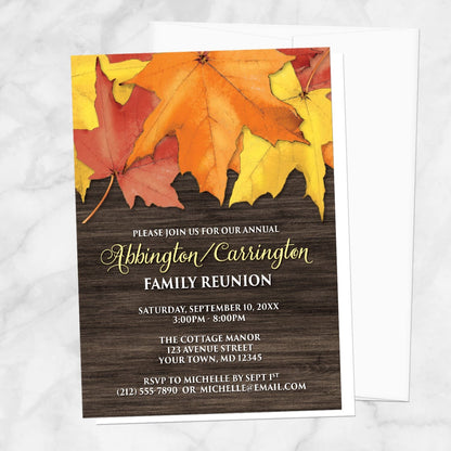 Rustic Autumn Leaves Wood Family Reunion Invitation on a marble surface with a white envelope.