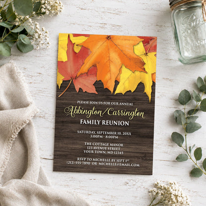 Rustic Autumn Leaves Wood Family Reunion Invitation on a light wooden surface with plants and a small mason jar.