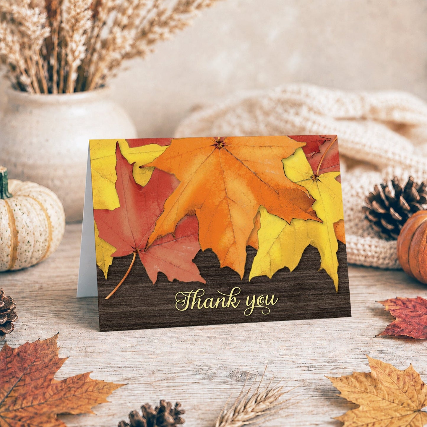 Rustic Autumn Leaves Wood Thank You Card shown on a tabletop with a vase, fall leaves, autumn decor, and a blanket.