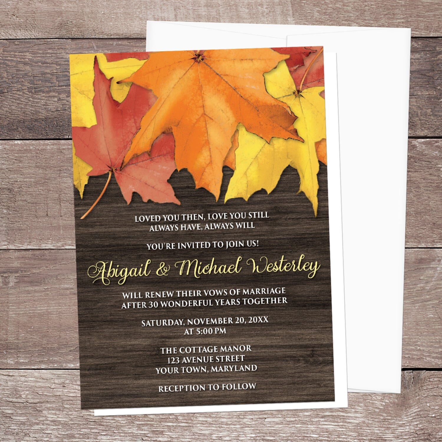 Rustic Autumn Leaves Wood Vow Renewal Invitation shown on a brown wood surface with a white envelope.