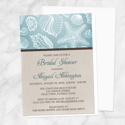 Rustic Beach Linen Seashell Bridal Shower Invitation shown on a marble surface with a white envelope.