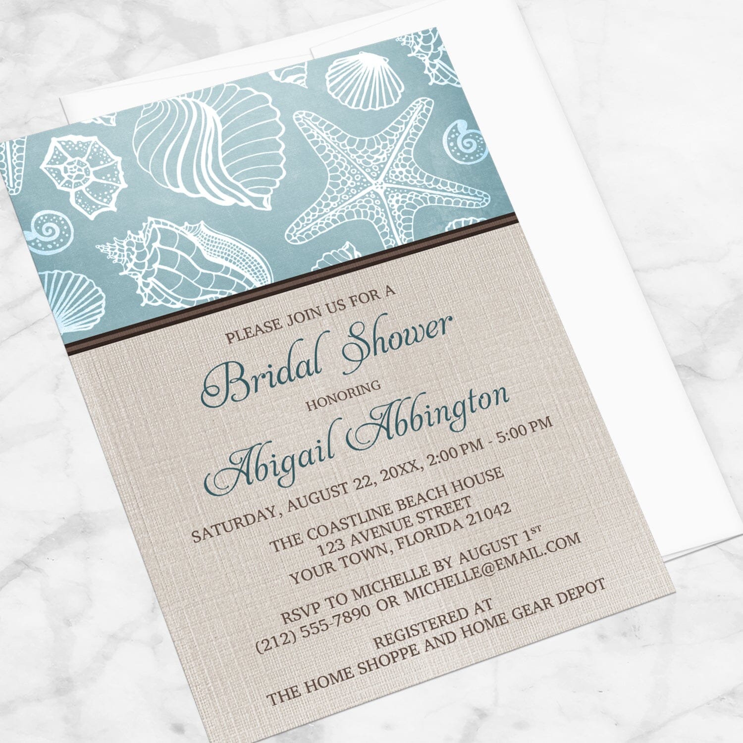 Rustic Beach Linen Seashell Bridal Shower Invitation shown at an angle on a marble surface with a white envelope.