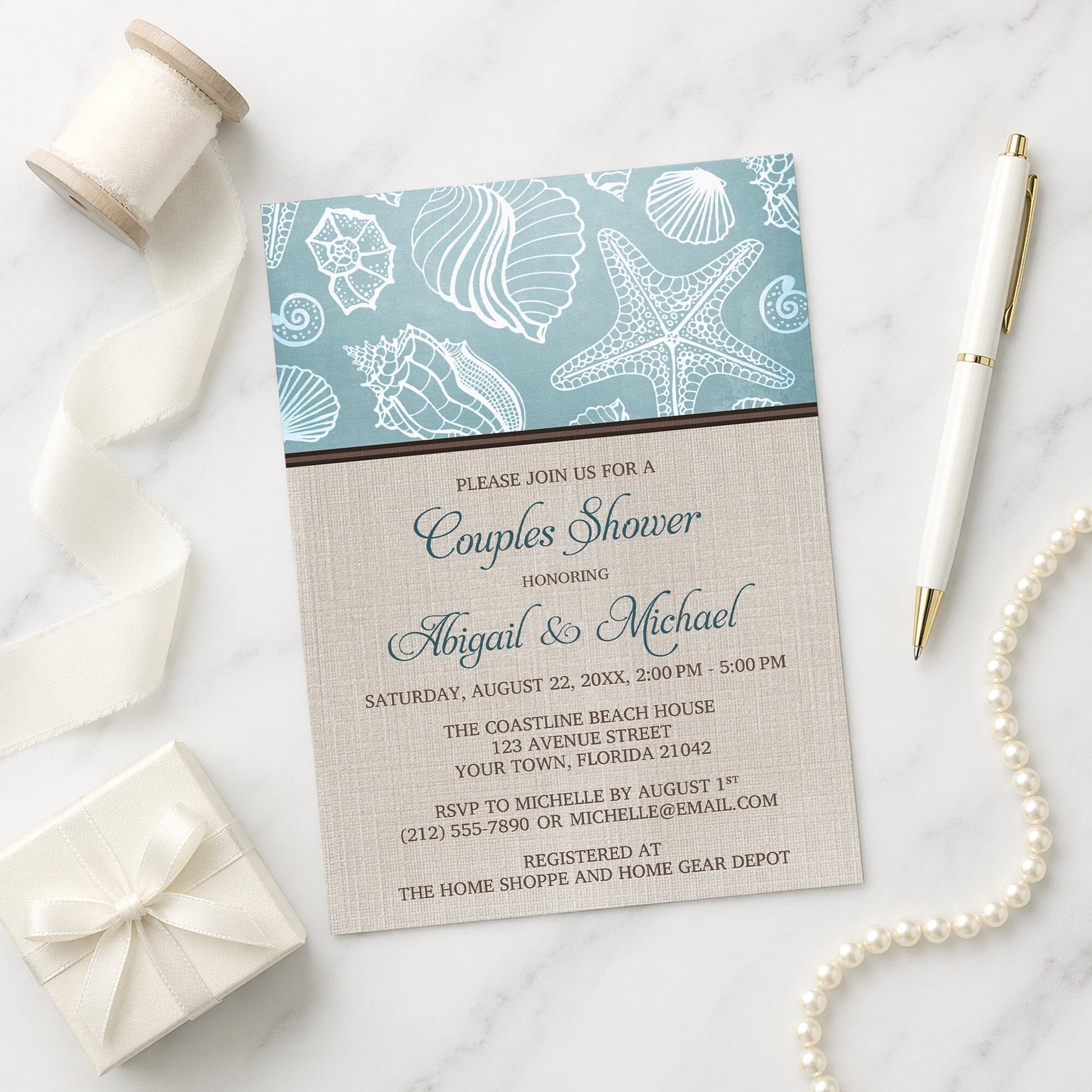 Rustic Beach Linen Seashell Couples Shower Invitation shown on a marble surface with a white gift box, pen, ribbon, and pearls.