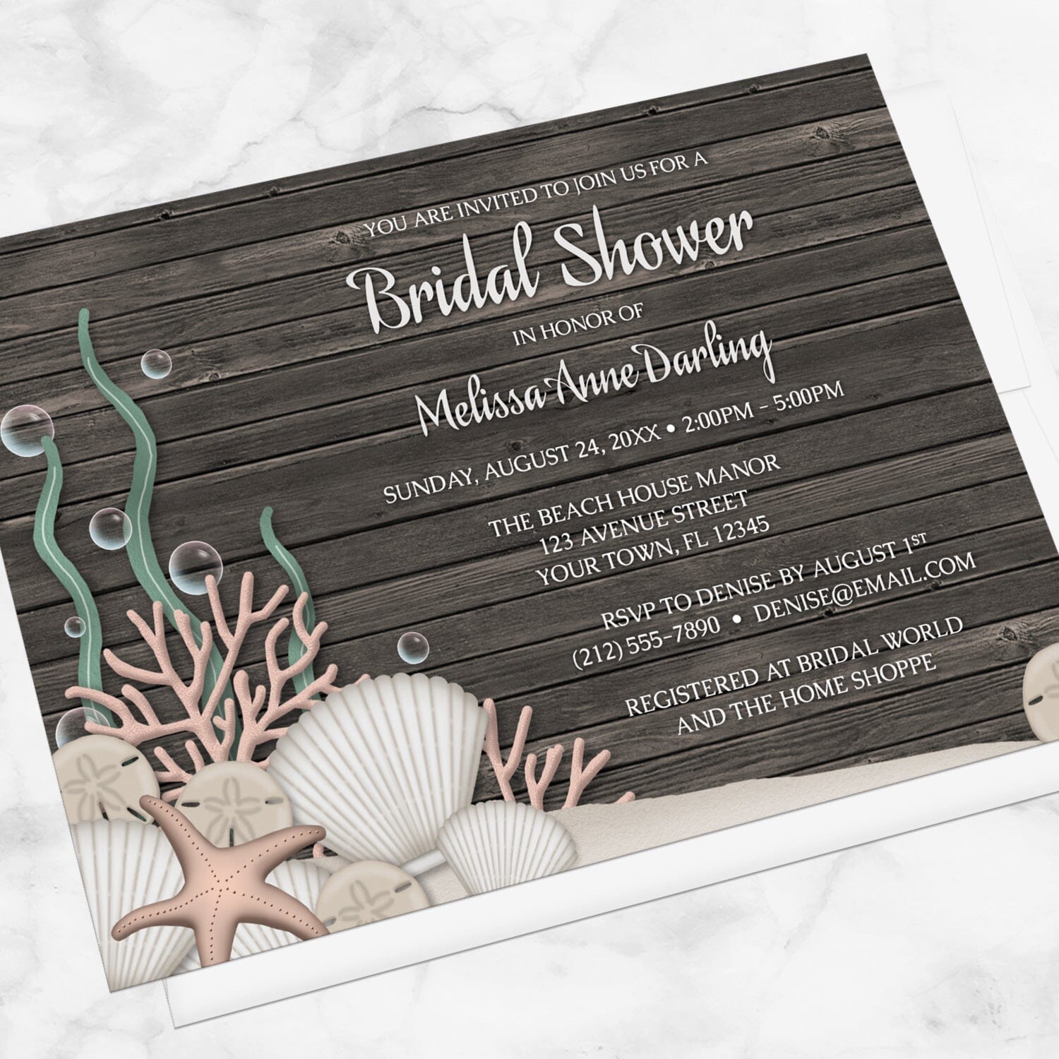 Rustic Beach Seashells and Wood Bridal Shower Invitation shown at an angle on a marble surface