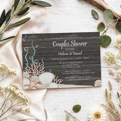 Rustic Beach Seashells and Wood Couples Shower Invitation shown on a light wooden surface with spring and summer plants.