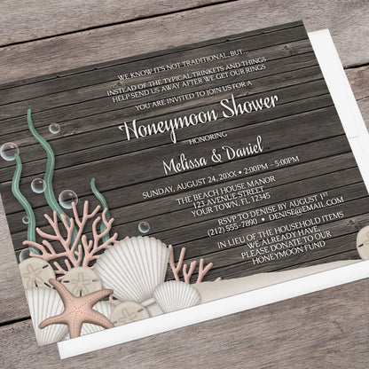 Rustic Beach Seashells and Wood Honeymoon Shower Invitation shown at an angle on a brown wood surface with a white envelope.