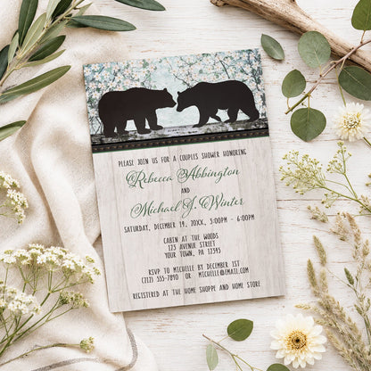 Rustic Bear Floral Wood Couples Shower Invitation shown on a light wooden surface with spring and summer plants.