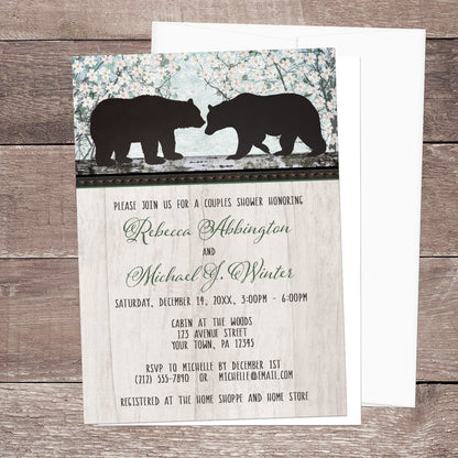 Rustic Bear Floral Wood Couples Shower Invitation shown on a brown wood surface with a white envelope.