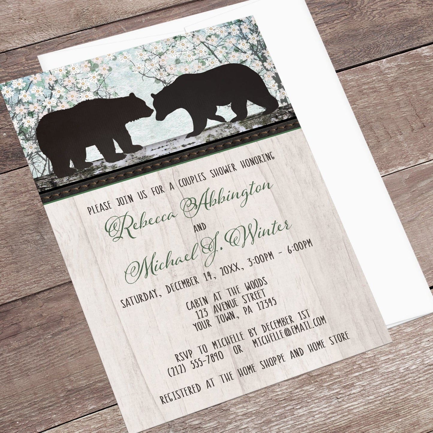 Rustic Bear Floral Wood Couples Shower Invitation shown at an angle on a brown wood surface with a white envelope.