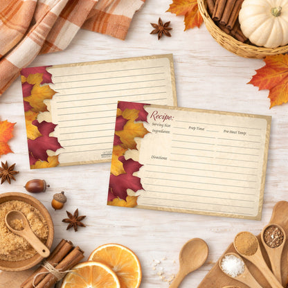 Two Rustic Burgundy Gold Autumn Recipe Cards on a wooden surface with fall decorations.