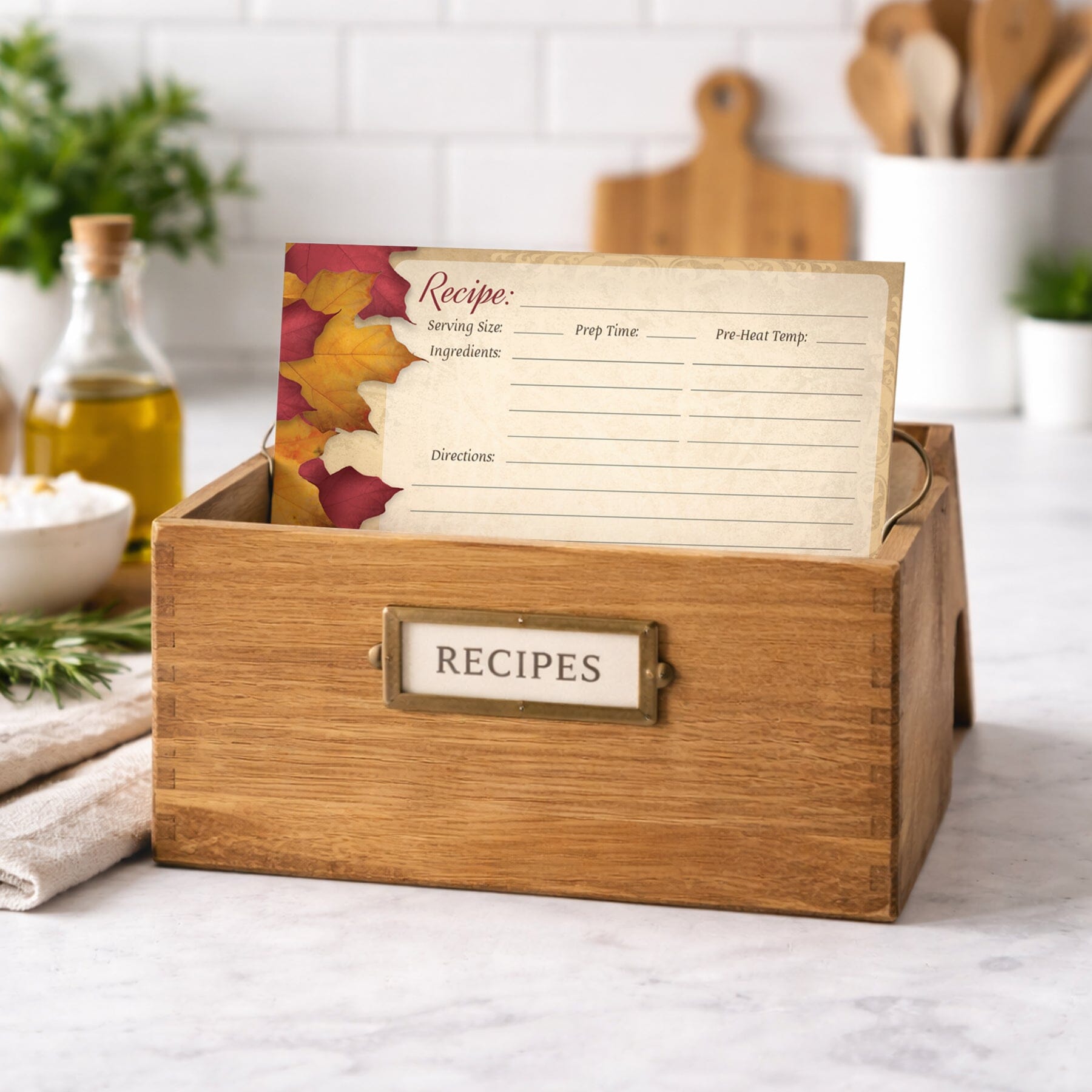 Wooden recipe box with open lid showing a Rustic Burgundy Gold Autumn Recipe Card on a kitchen counter.