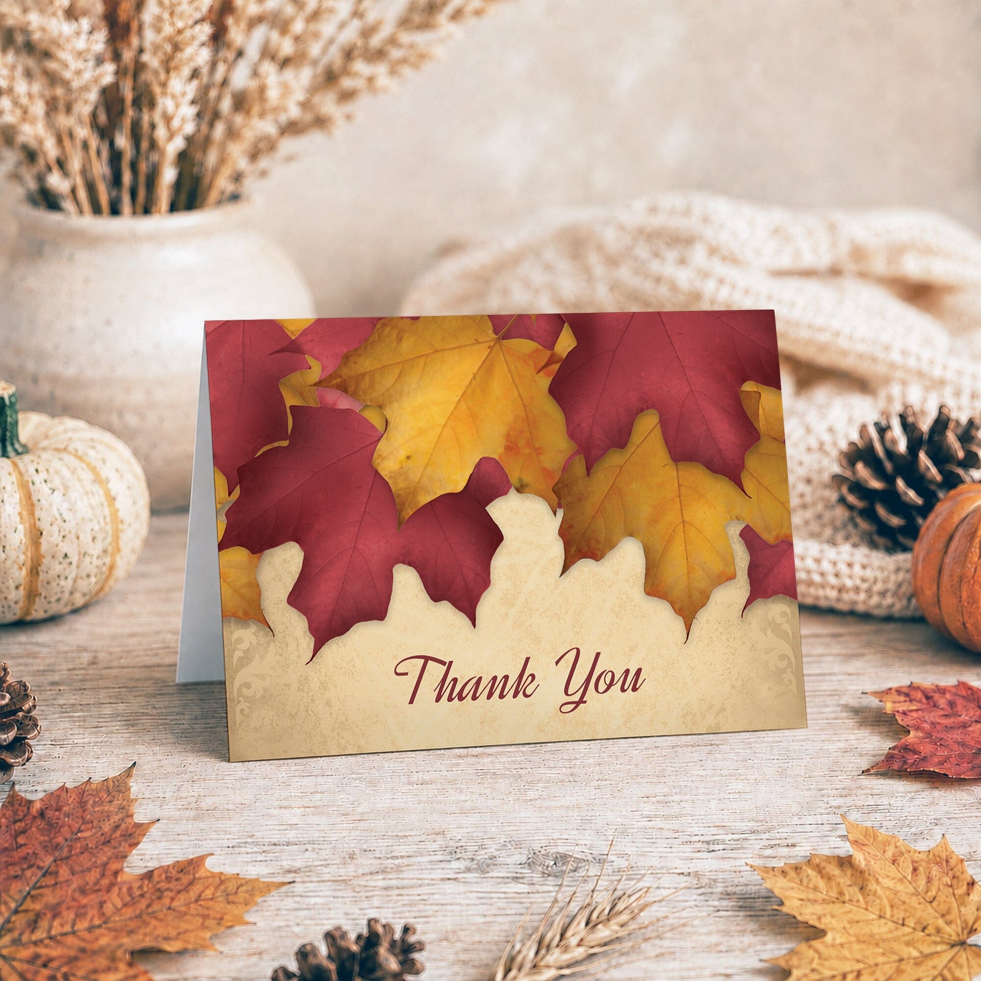 Rustic Burgundy Gold Autumn Thank You Card shown on a tabletop with fall leaves and autumn decor.