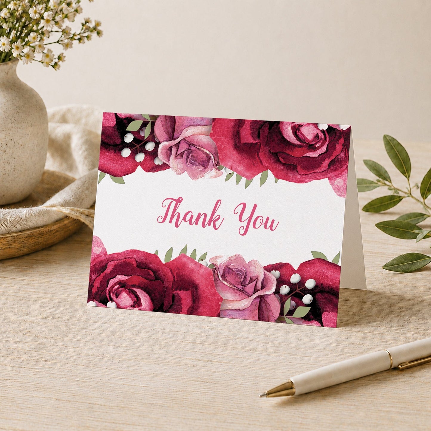 Rustic Burgundy Pink Rose Thank You Card shown on a desk with a vase, plants, and a pen.
