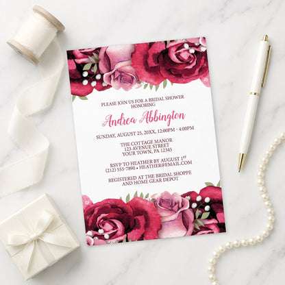 Rustic Burgundy Pink Rose White Bridal Shower Invitation on a marble surface with decorative items.