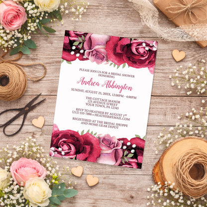 Rustic Burgundy Pink Rose White Bridal Shower Invitation on a wooden background with lace, flowers, and twine.