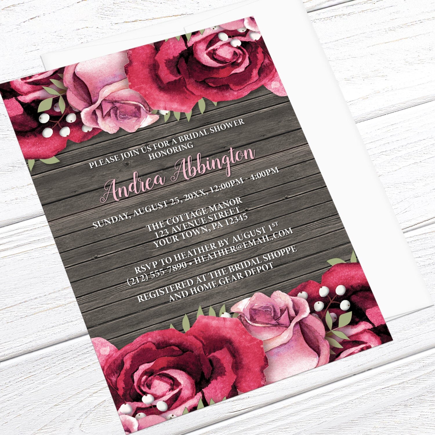 Rustic Burgundy Pink Rose Wood Bridal Shower Invitation shown at an angle on a light wood surface with a white envelope.