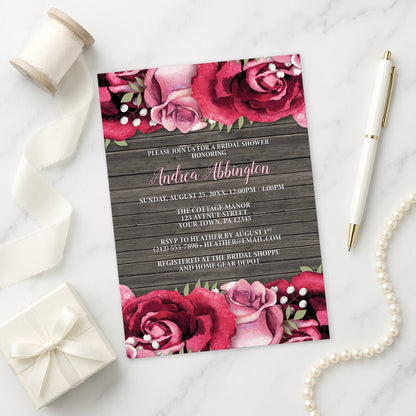Rustic Burgundy Pink Rose Wood Bridal Shower Invitation shown on a marble surface with a white gift box, pen, ribbon, and pearls.