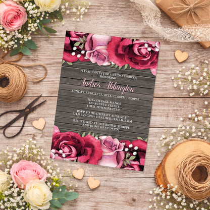 Rustic Burgundy Pink Rose Wood Bridal Shower Invitation shown on a wooden surface with spring and summer flowers, small wood hearts, and twine.