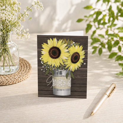 Rustic Burlap and Lace Tin Can Sunflower Note Card shown on a tabletop with a vase, spring and summer flowers, and a pen.
