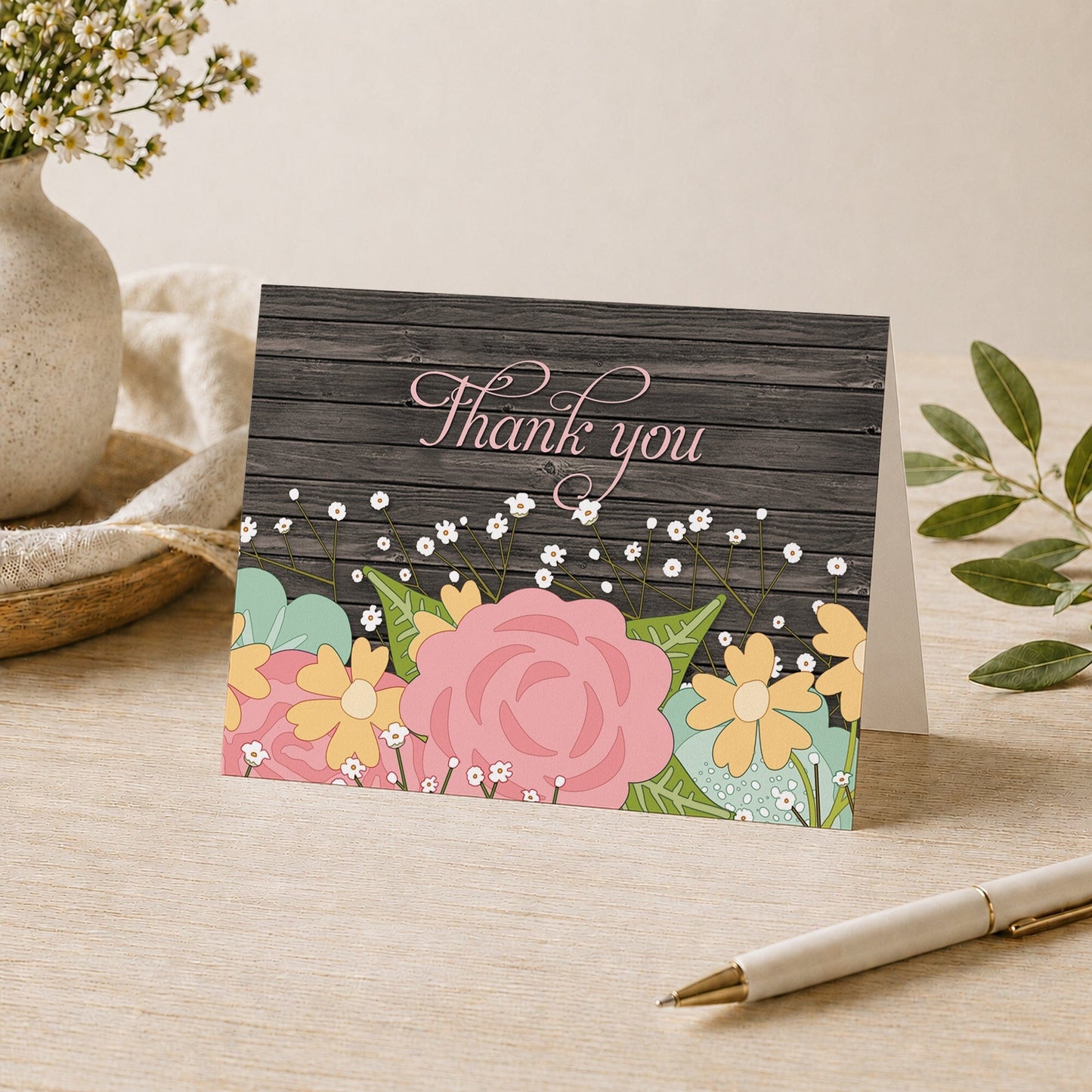 Rustic Floral Wood Baby's Breath Thank You Card shown on a desk with a vase, plants, and a pen.