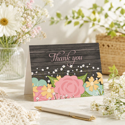 Rustic Floral Wood Baby's Breath Thank You Card shown on a tabletop with a vase, spring and summer flowers, and a pen.