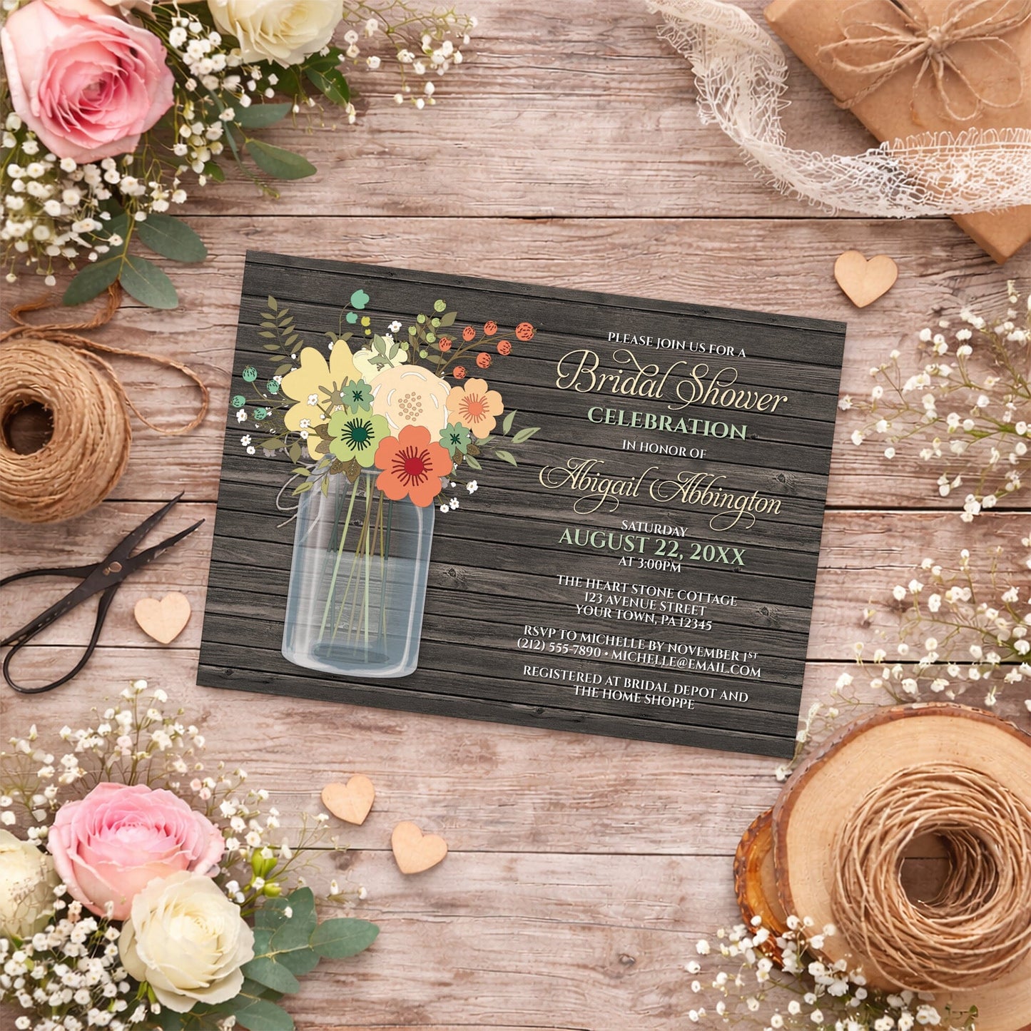 Rustic Floral Wood Mason Jar Bridal Shower Invitation on a wooden surface with decorative elements including flowers, wooden hearts, white lace, and twine.