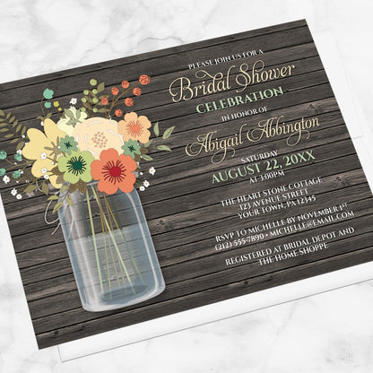 Rustic Floral Wood Mason Jar Bridal Shower Invitation shown at an angle on a marble surface