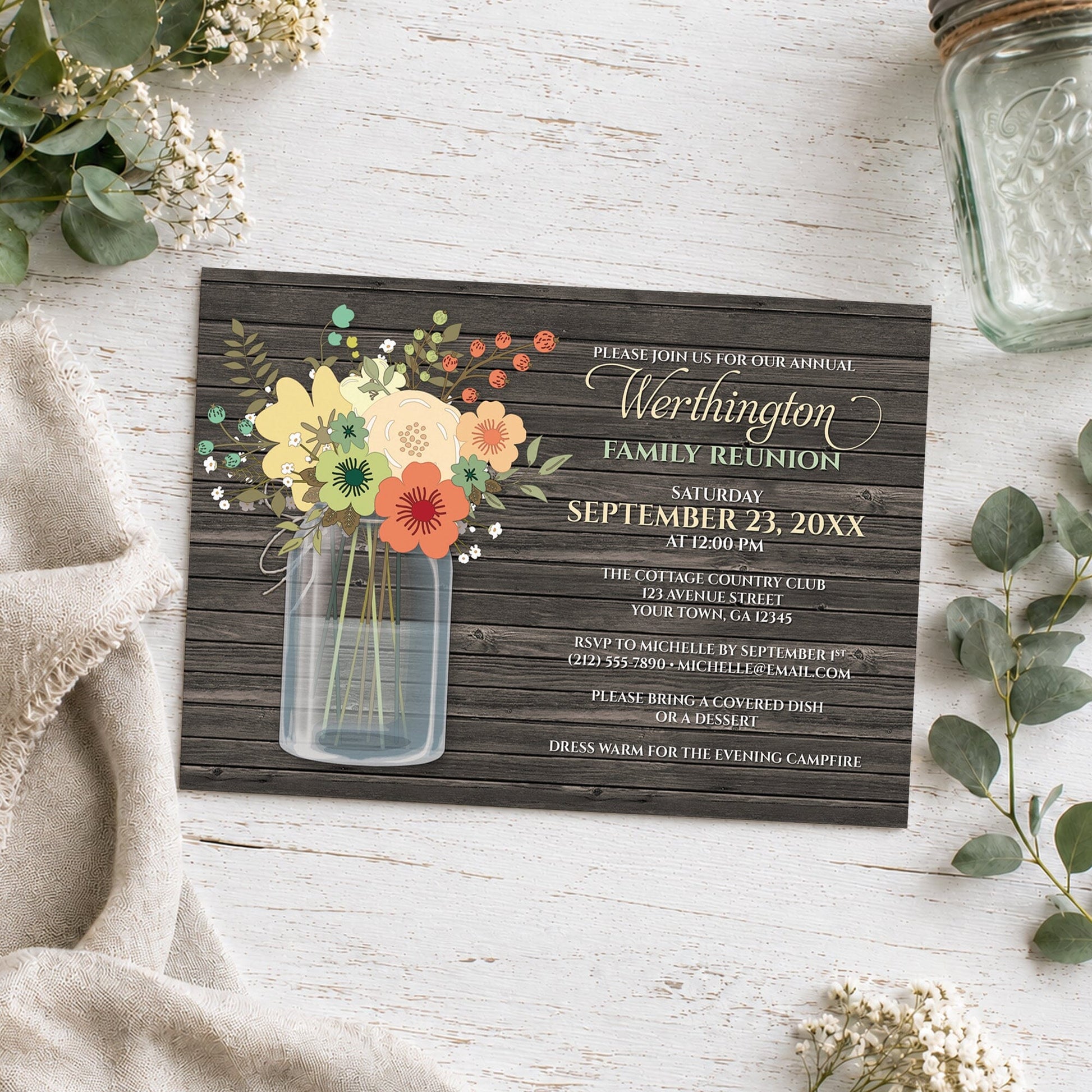 Rustic Floral Wood Mason Jar Family Reunion Invitation shown on a wooden surface with plants and a mason jar.