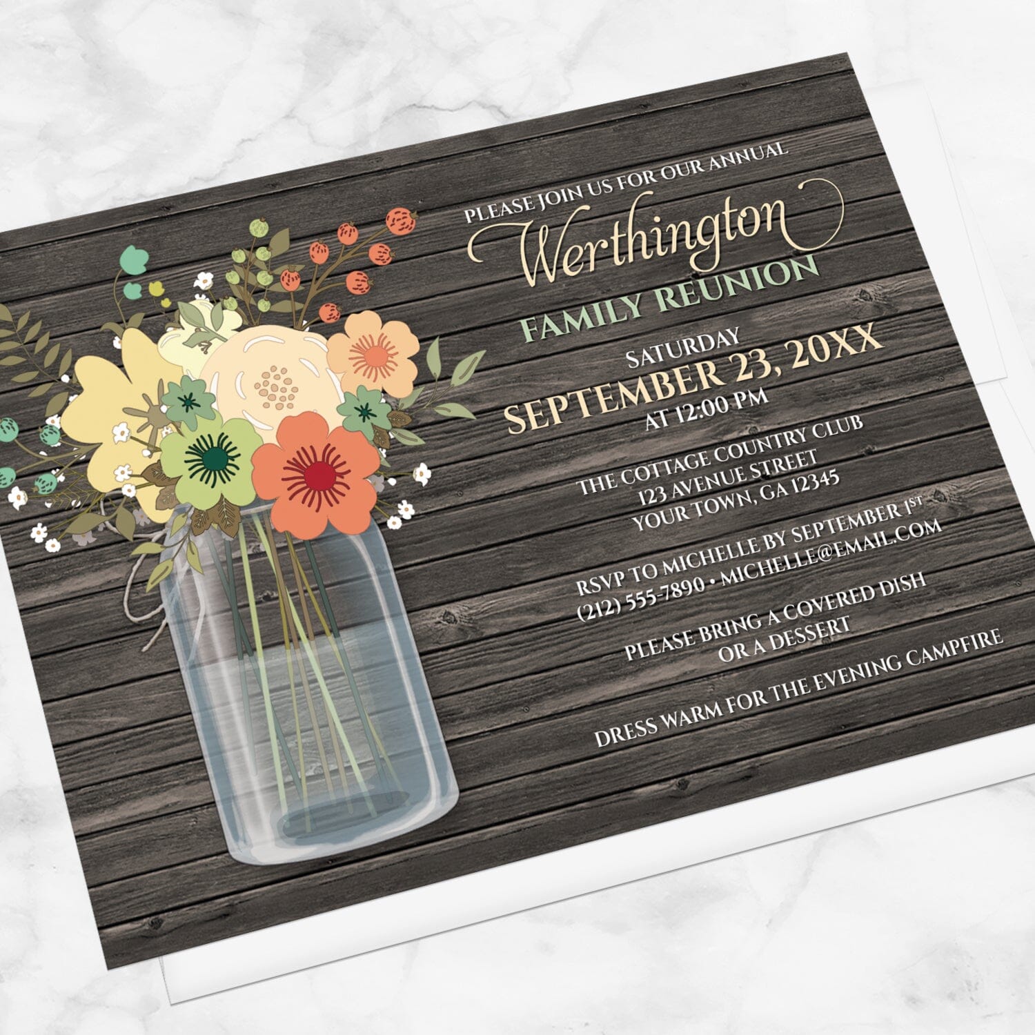 Rustic Floral Wood Mason Jar Family Reunion Invitation shown at an angle on marble surface with a white envelope.
