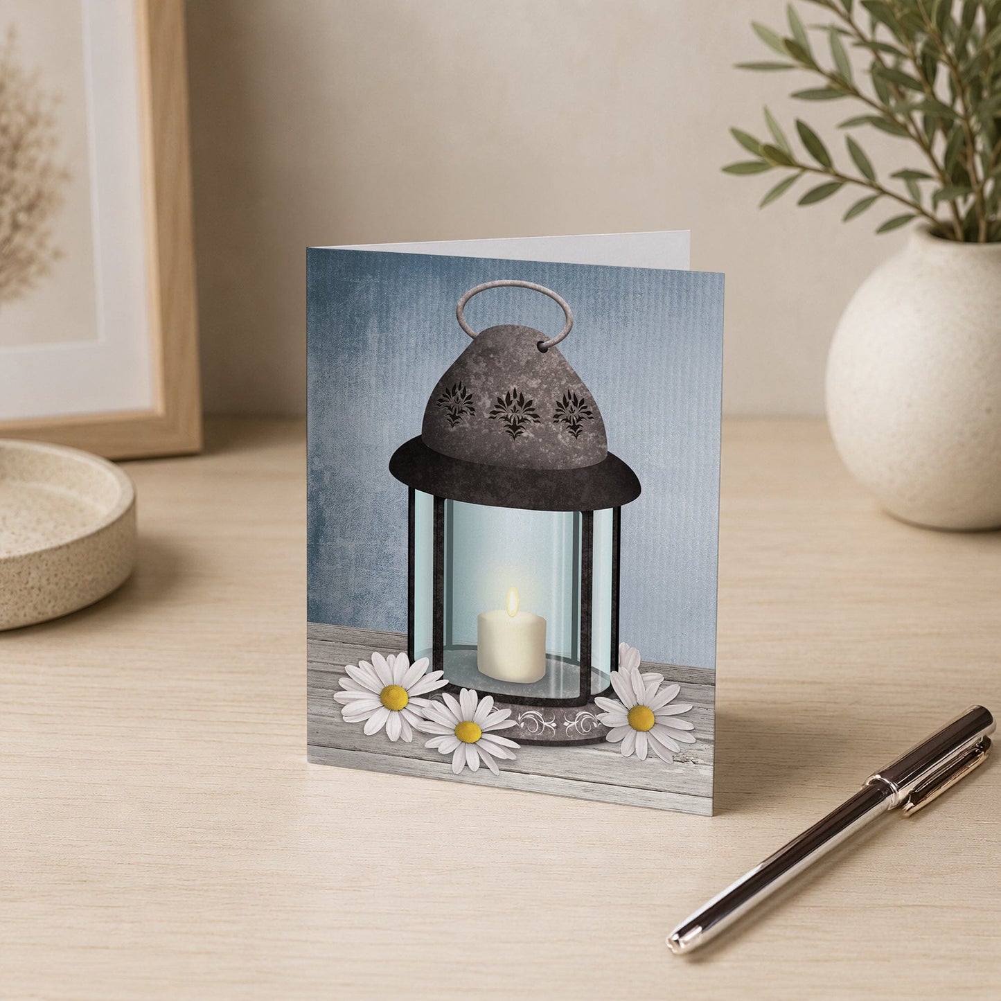 Rustic Lantern Daisy Note Card shown on a desk with a vase and a pen.