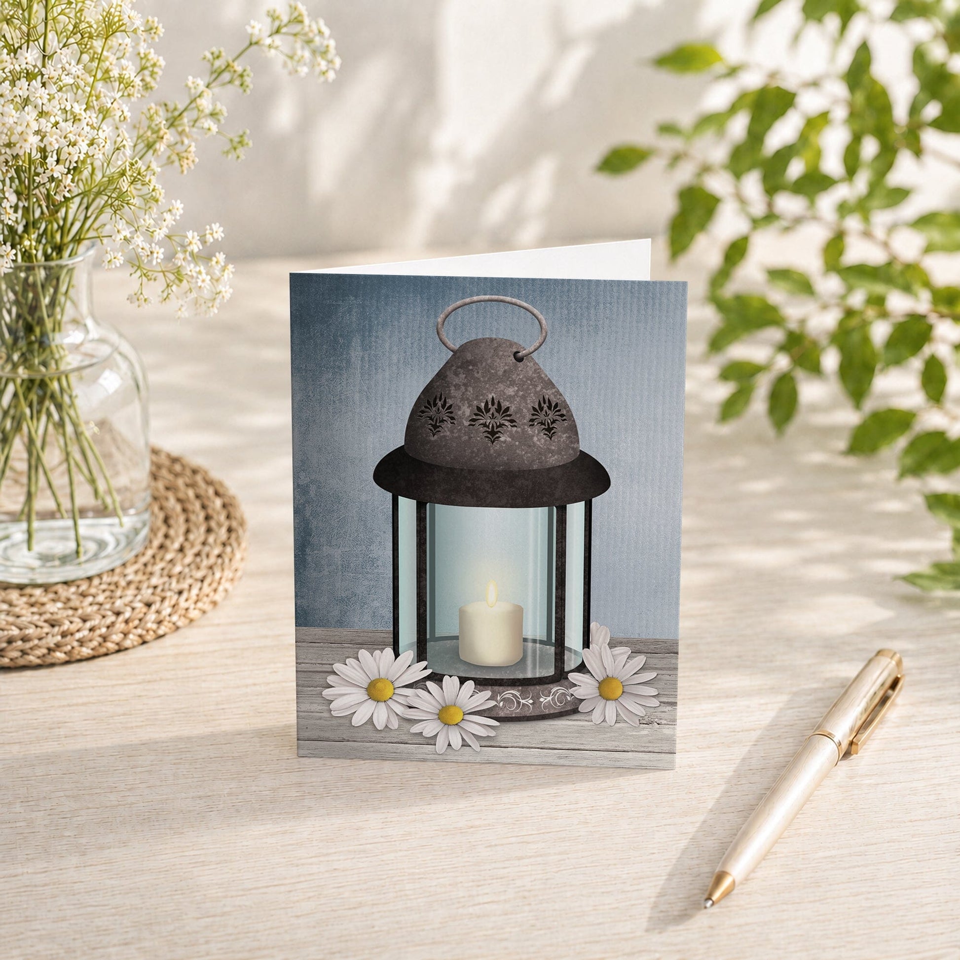 Rustic Lantern Daisy Note Card shown on a tabletop with a vase, spring and summer flowers, and a pen.