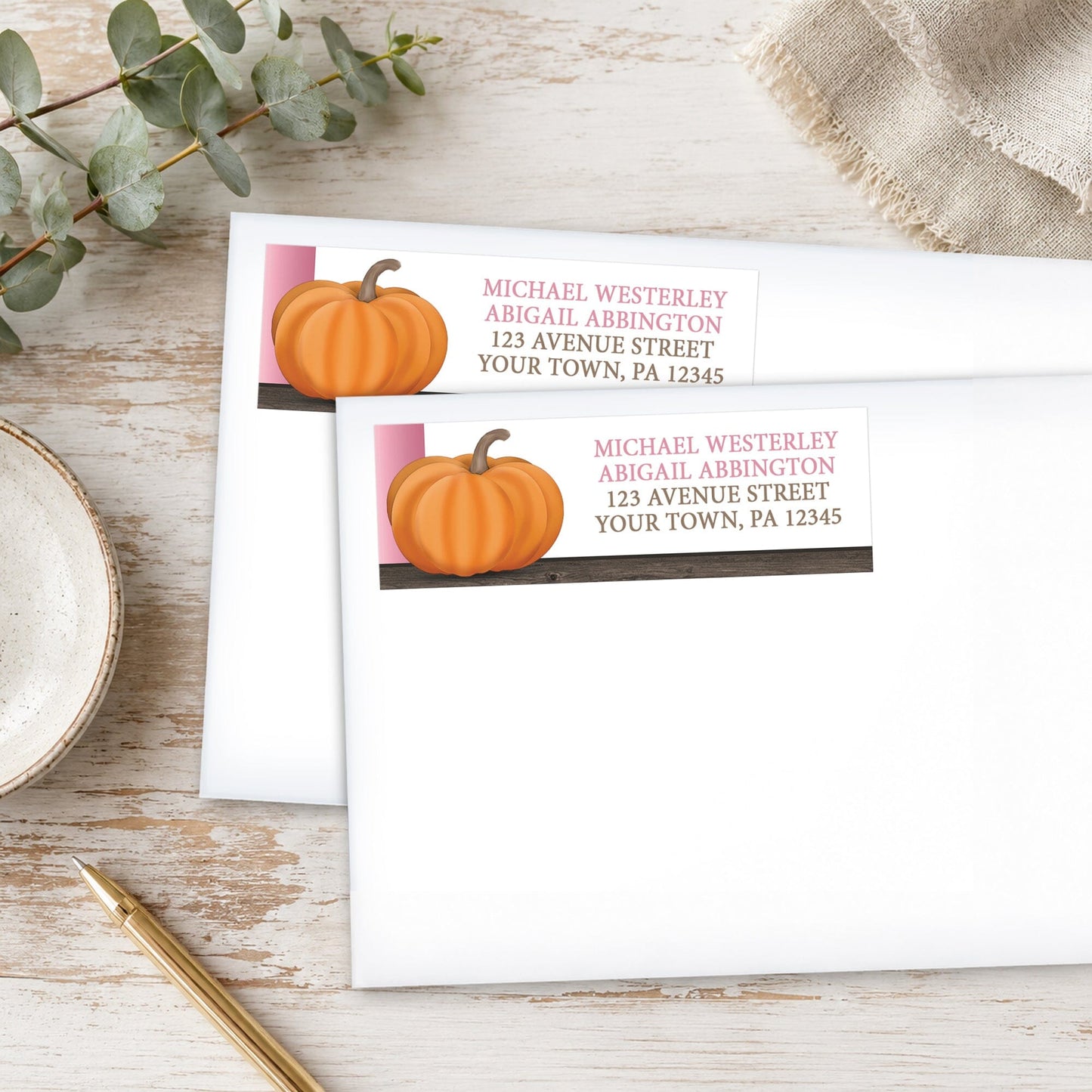 Rustic Orange Pink Pumpkin Address Labels, shown on white envelopes, on a wooden surface with eucalyptus leaves and a pen.