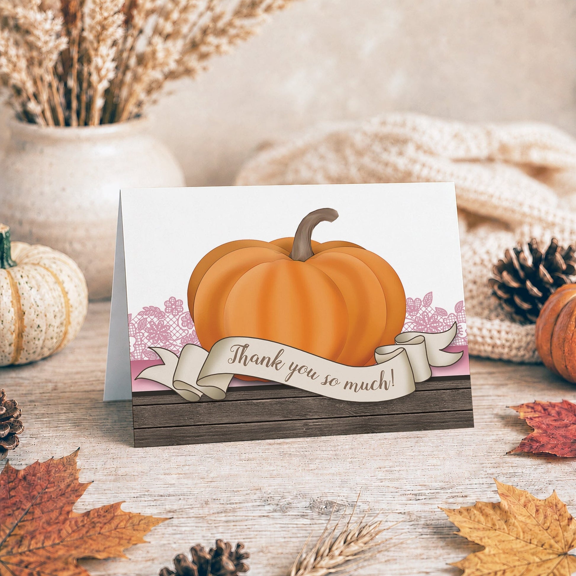 Rustic Orange Pink Pumpkin Thank You Card shown on a tabletop with a vase, fall leaves and autumn decor.