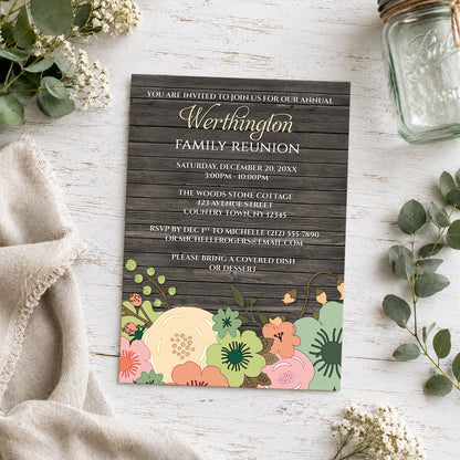 Rustic Orange Teal Floral Wood Family Reunion Invitation shown on a light wooden surface with plants and a small mason jar.