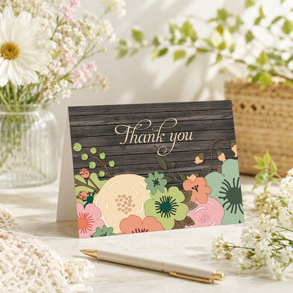 Rustic Orange Teal Floral Wood Thank You Card shown on a tabletop with a vase, spring and summer flowers, and a pen.