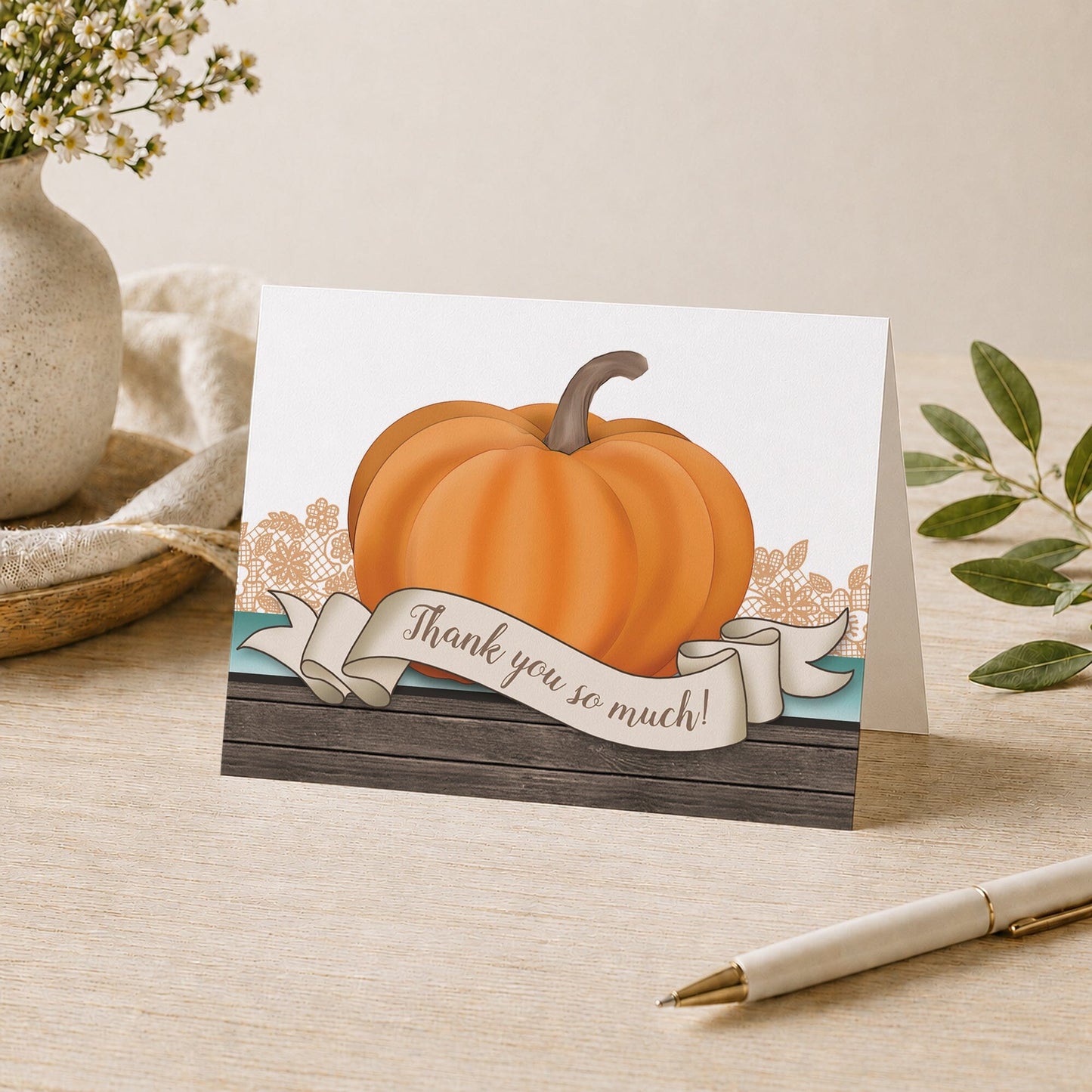 Rustic Orange Teal Pumpkin Thank You Card shown on a tabletop with a vase, plants, and a pen.