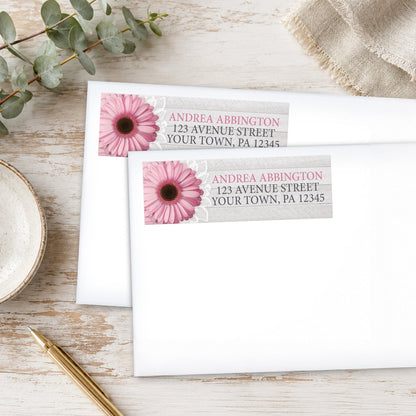 Rustic Pink Daisy Gray Wood Address Labels, shown on white envelopes, on a wooden surface with eucalyptus leaves and a pen.