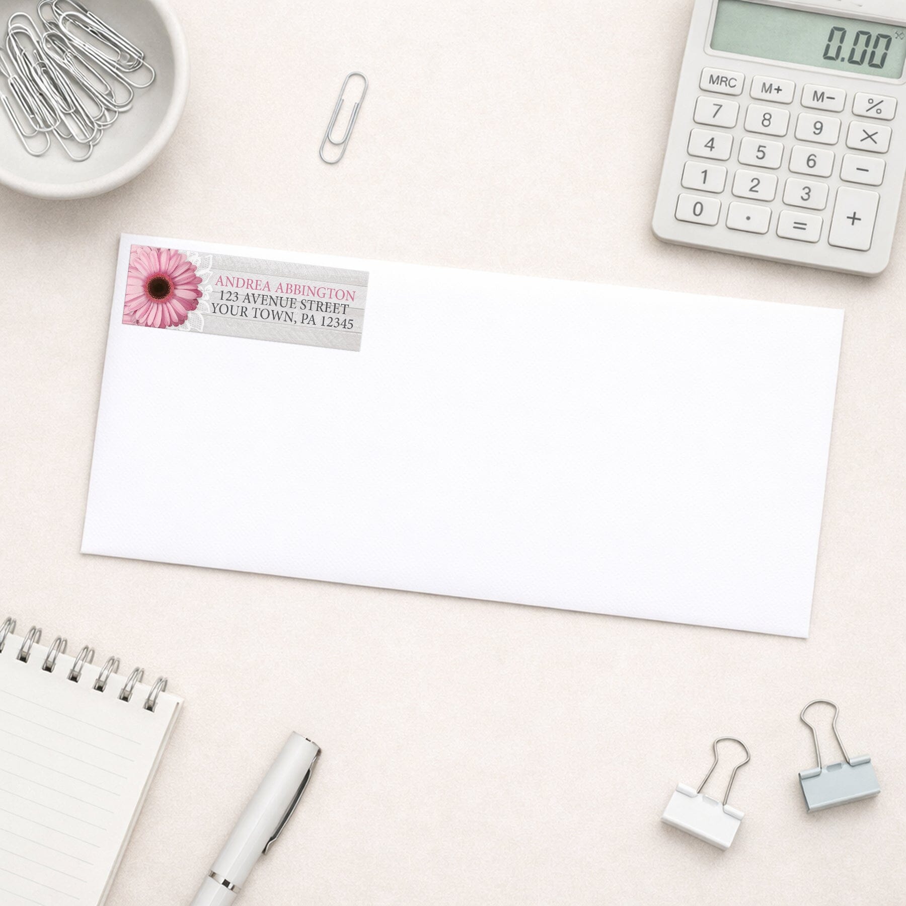 Rustic Pink Daisy Gray Wood Address Label shown on a white envelope with everyday office supplies