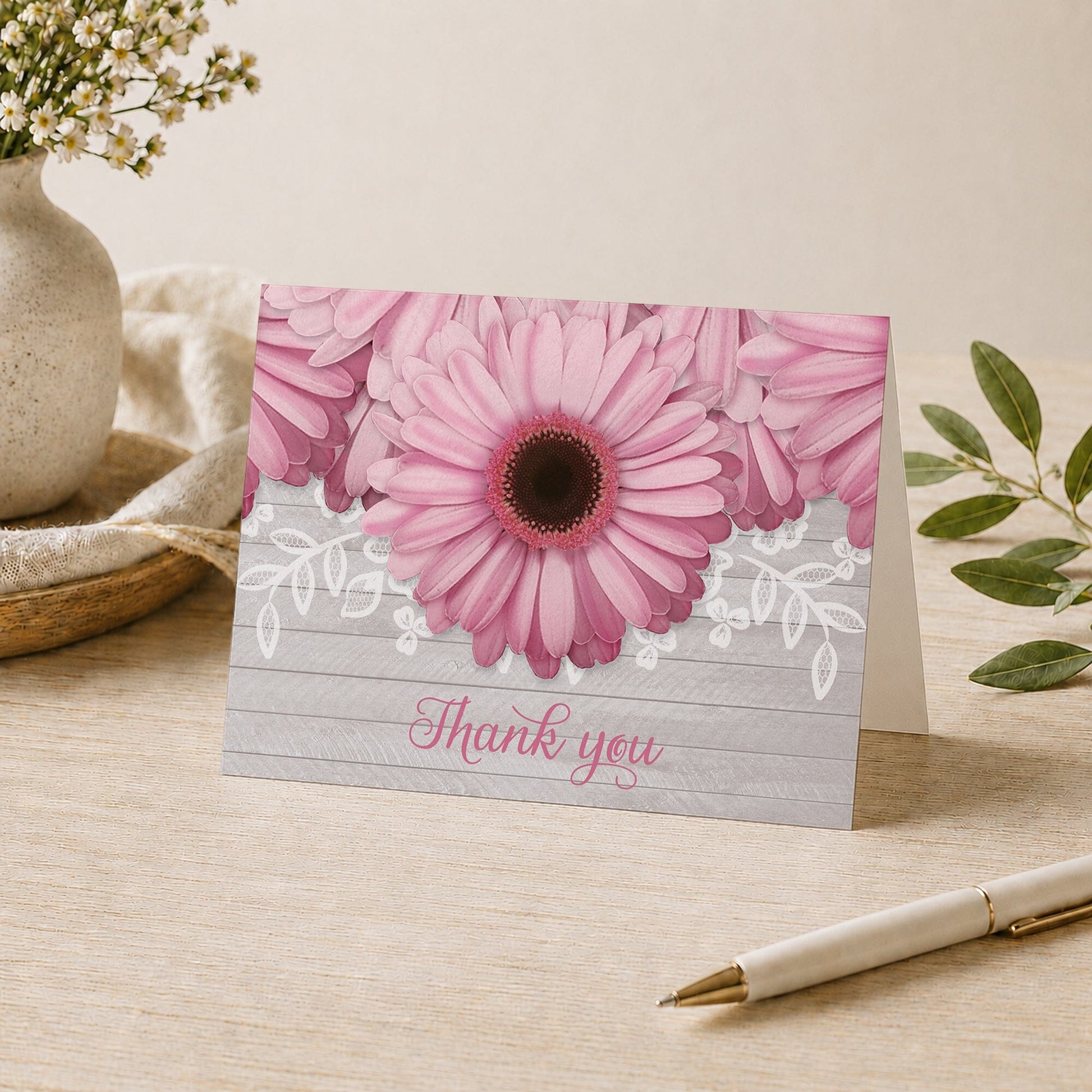 Rustic Pink Daisy Gray Wood Thank You Card on a desk with a vase and a pen.