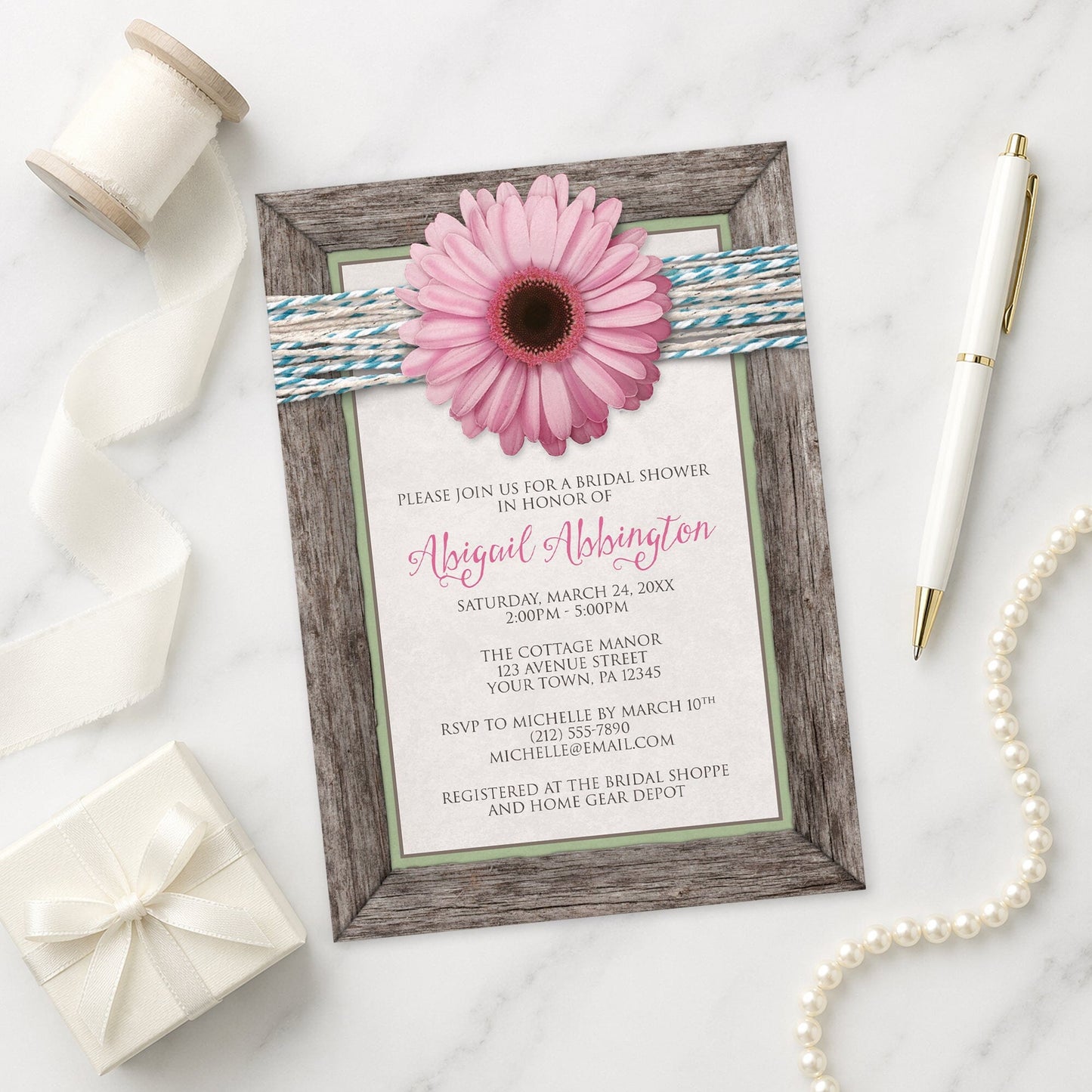 Rustic Pink Daisy Turquoise Wood Bridal Shower Invitation shown on a marble surface with a white gift box, pen, ribbon, and pearls.